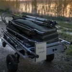 Chariot de peche carpe tout terrain au bord de l’étang au crépuscule