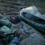 Pack raft ouvert avant la mise à l’eau, lac alpin, gilet et pagaie